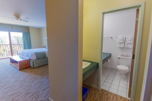 a bedroom with a bed and a bathroom with a toilet at Liscombe Lodge Resort & Conference Center in Liscomb