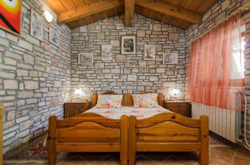 a bedroom with a bed and a stone wall at Apartments Marija & Pepa in Rovinj