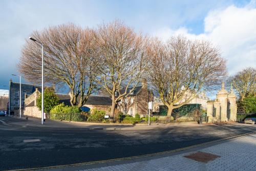 an empty street with trees and a building at The Queens View in Edinburgh