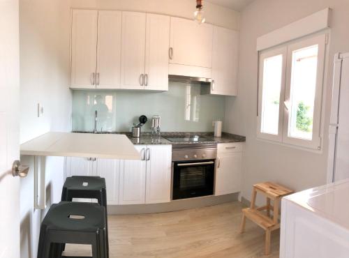 a kitchen with white cabinets and a counter top at Casa Xuncal in Tui