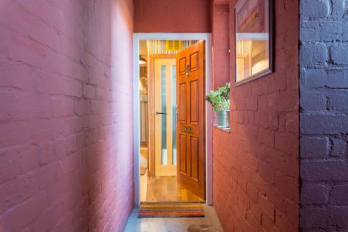 a hallway with a pink wall and a door at The Queens View in Edinburgh