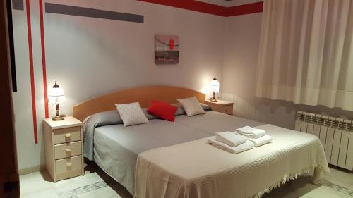 een slaapkamer met twee bedden met rode kussens erop bij La casa de Lu in Archidona