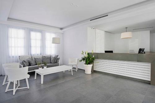 a living room with a couch and a table and chairs at Acroterra Rosa Luxury Suites & Spa in Akrotiri