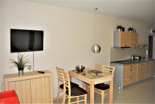 a kitchen with a table and chairs and a television at Apartamenty Gabrysia 8 in Międzywodzie