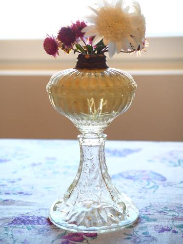 a glass vase with flowers in it on a table at Memórias Charme Residences in Covilhã