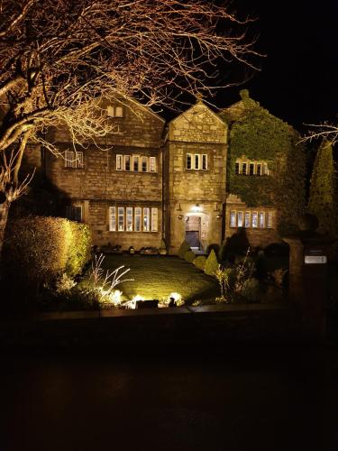 an old stone house at night with lights at Stirk House Hotel in Clitheroe
