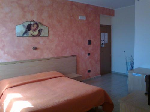 una camera da letto con un letto e un dipinto sul muro di Life Hotel ad Ariano Irpino
