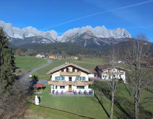a house in a field with mountains in the background at Haus Drei Linden in Going