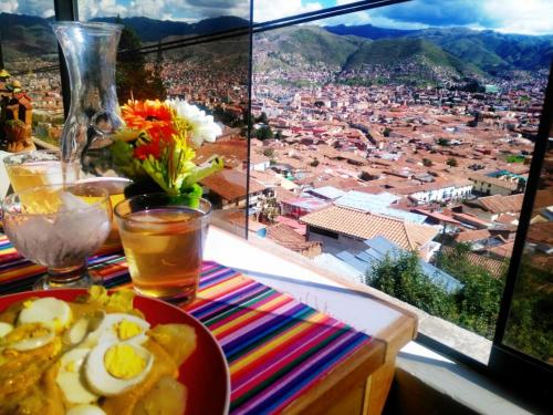 a plate of food on a table with a view of a city at Casa Mirador guesthouse in Cusco