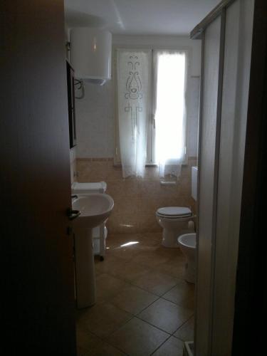 a bathroom with a sink and a toilet and a window at Liana monolocale in San Vincenzo
