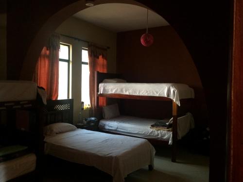 Hostel Del Piamonte 2 في كيتو: غرفة بسريرين بطابقين ونافذة