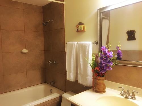 y baño con lavabo y ducha con flores púrpuras. en San Marcos 124 Gran Pacifica Resort, en San Diego