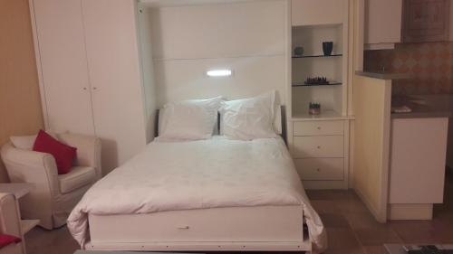 une petite chambre avec un lit et une chaise dans l'établissement Studio cosy à Villefranche sur mer, à Villefranche-sur-Mer