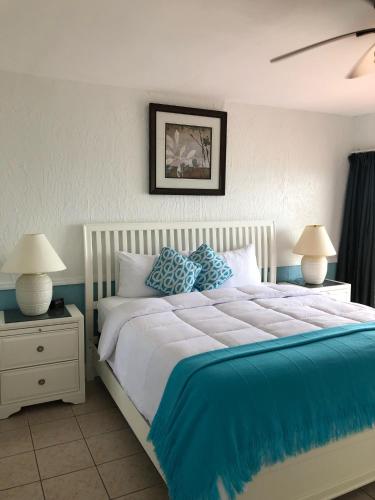a bedroom with a large bed with blue sheets and pillows at Edgewater Lodge in Layton
