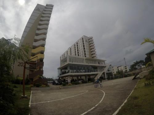 a large building with a parking lot in front of it at Cozy Studio near Beaches with NetFlix and Pool in Mactan