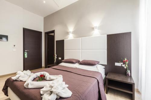 1 dormitorio con 1 cama grande y toallas. en Stardust Rome Guest House en Roma
