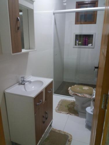 Un baño con ducha, lavabo e inodoro. en H&C Pousada Ap, en São Gabriel