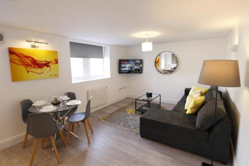 a living room with a black couch and a table at Willow Serviced Apartments - 22 in Cardiff