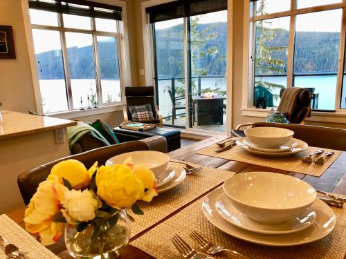 a dining room table with plates and flowers on it at Port Renfrew Vacation Rentals in Port Renfrew