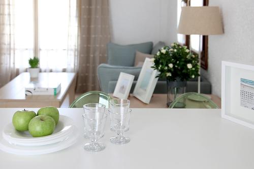 a table with a plate of apples and glasses at Skopelos Village Hotel in Skopelos Town