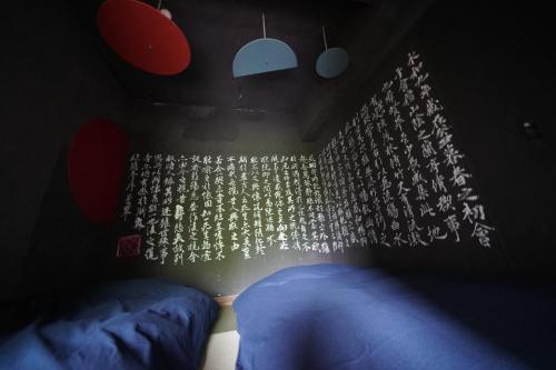 a dark room with a bed and a wall with lights at ARtINn 極寒藝術伝染装置 in Teshikaga