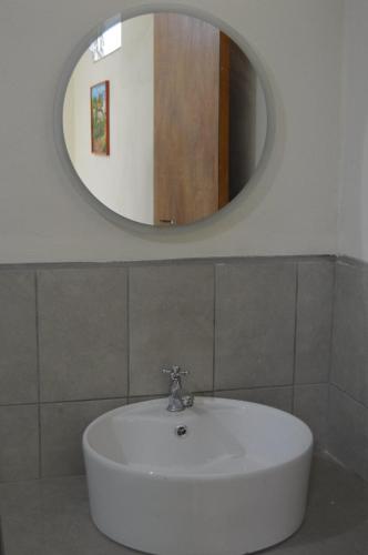 a white sink in a bathroom with a mirror at Hostal Libertad in Masaya