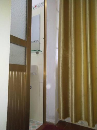 a bathroom with a shower with a yellow curtain at Nhà hàng Nhà nghỉ Dù Lượn Khau Phạ in Mù Cang Chải