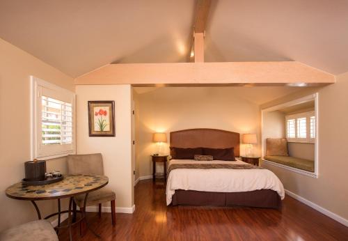 a bedroom with a bed and a table at Sunset Inn Pacific Grove in Pacific Grove