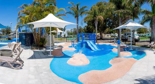 a pool with a water slide and an umbrella at NRMA Forster Tuncurry in Tuncurry