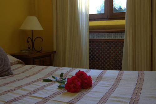 a red flower sitting on top of a bed at Hostal Rural Elosta in Lekunberri