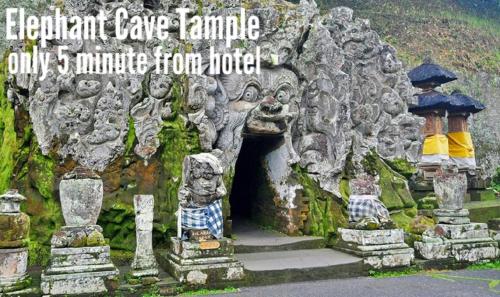 a stone cave with some statues in front of it at Adil Villa & Resort in Ubud