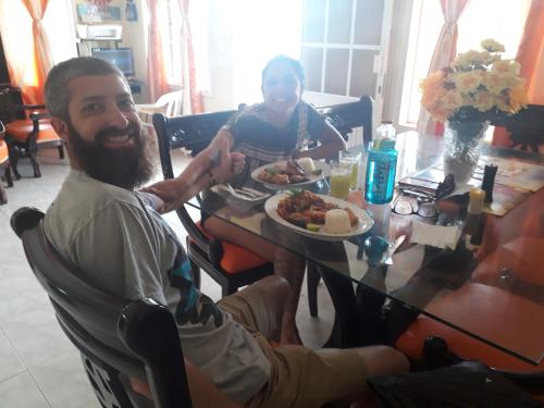 a man sitting at a table with a plate of food at Posada Ashanty in Providencia