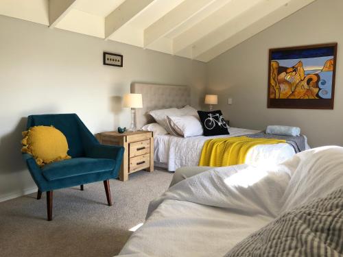 ハミルトンにあるCedar Park Bed & Breakfastのベッドルーム1室(ベッド2台、青い椅子付)