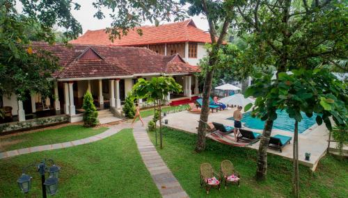 a house with a swimming pool next to a yard at Flamingo Boutique Hotel & Ayurvedic spa in Mararikulam