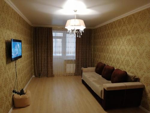 a living room with a couch and a television at Апартаменты, Московская 97 in Pyatigorsk