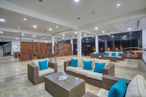a lobby with couches and blue pillows at Athena Lake by Seedevi in Dambulla