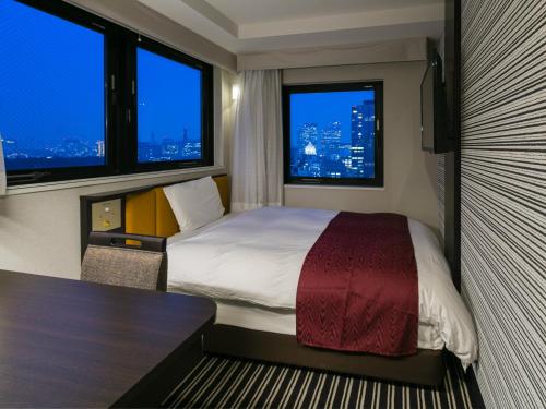 a hotel room with a bed and two windows at APA Hotel Nagatacho Hanzomon Ekimae in Tokyo
