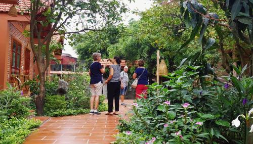 a group of people standing in a garden at Trang An Village Homestay in Ninh Binh
