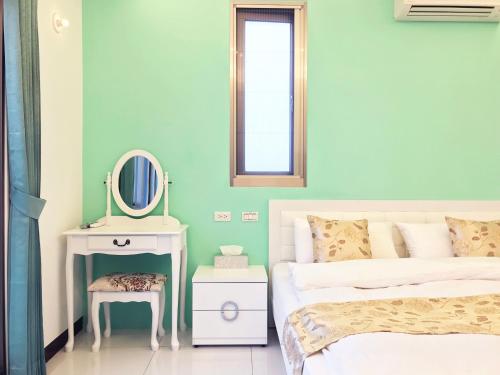 a bedroom with a bed and a mirror and a table at Yilan NAI-JI House in Dongshan