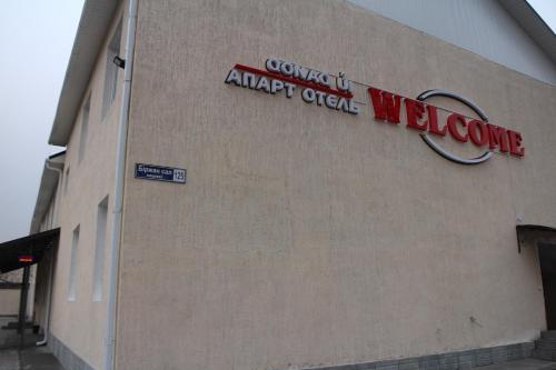 a building with a sign on the side of it at Апарт отель Welcome in Taldykorgan