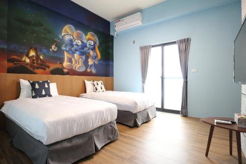 een slaapkamer met 2 bedden en een schilderij aan de muur bij 蘑燈民宿 Mushroom Light Homestay in Taitung