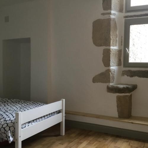une chambre avec un lit et une fenêtre dans l'établissement Maison de bourg avec cour privée, à Tallende