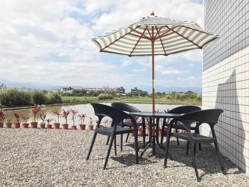 a table and chairs under an umbrella on a patio at Yilan NAI-JI House in Dongshan