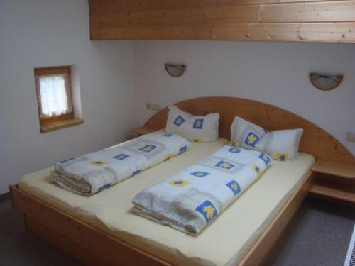 a bed with four pillows on it in a bedroom at Alpenhaus Christian in Neustift im Stubaital