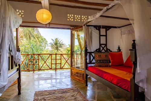 1 dormitorio con 1 cama y balcón en Villa Mashariki - luxury villa 400m from the beach, en Diani Beach