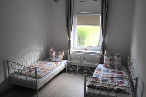 a small bedroom with two beds and a window at Doedelmoker in Wilhelmshaven