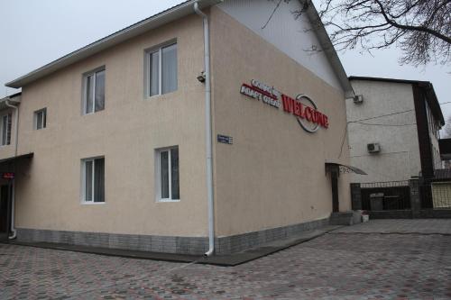 a building with a sign on the side of it at Апарт отель Welcome in Taldykorgan