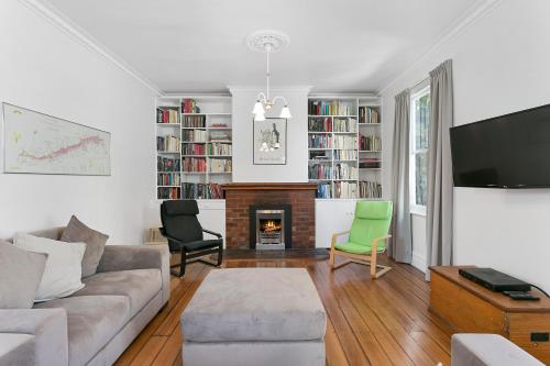 a living room with a couch and a fireplace at Amberley - circa 1880s Luxury - 5 b'rooms sleeps 9 in Sandy Bay
