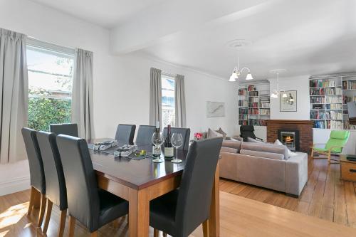 a dining room and living room with a table and chairs at Amberley - circa 1880s Luxury - 5 b'rooms sleeps 9 in Sandy Bay