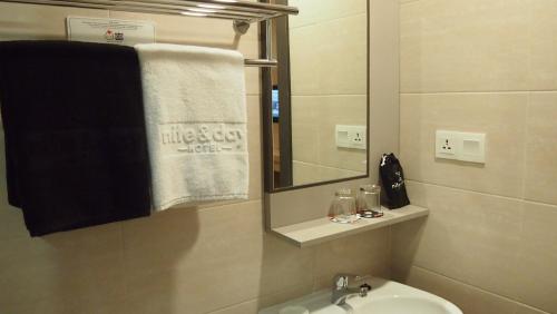 a bathroom with a sink and a mirror and a towel at Nite & Day Laguna Bintan in Tanjung Pinang 